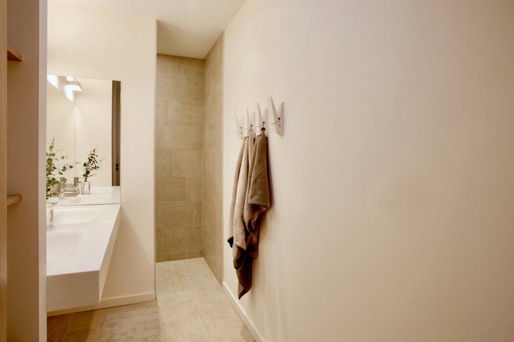 Baño con muros de acabado mate, estilo microcemento